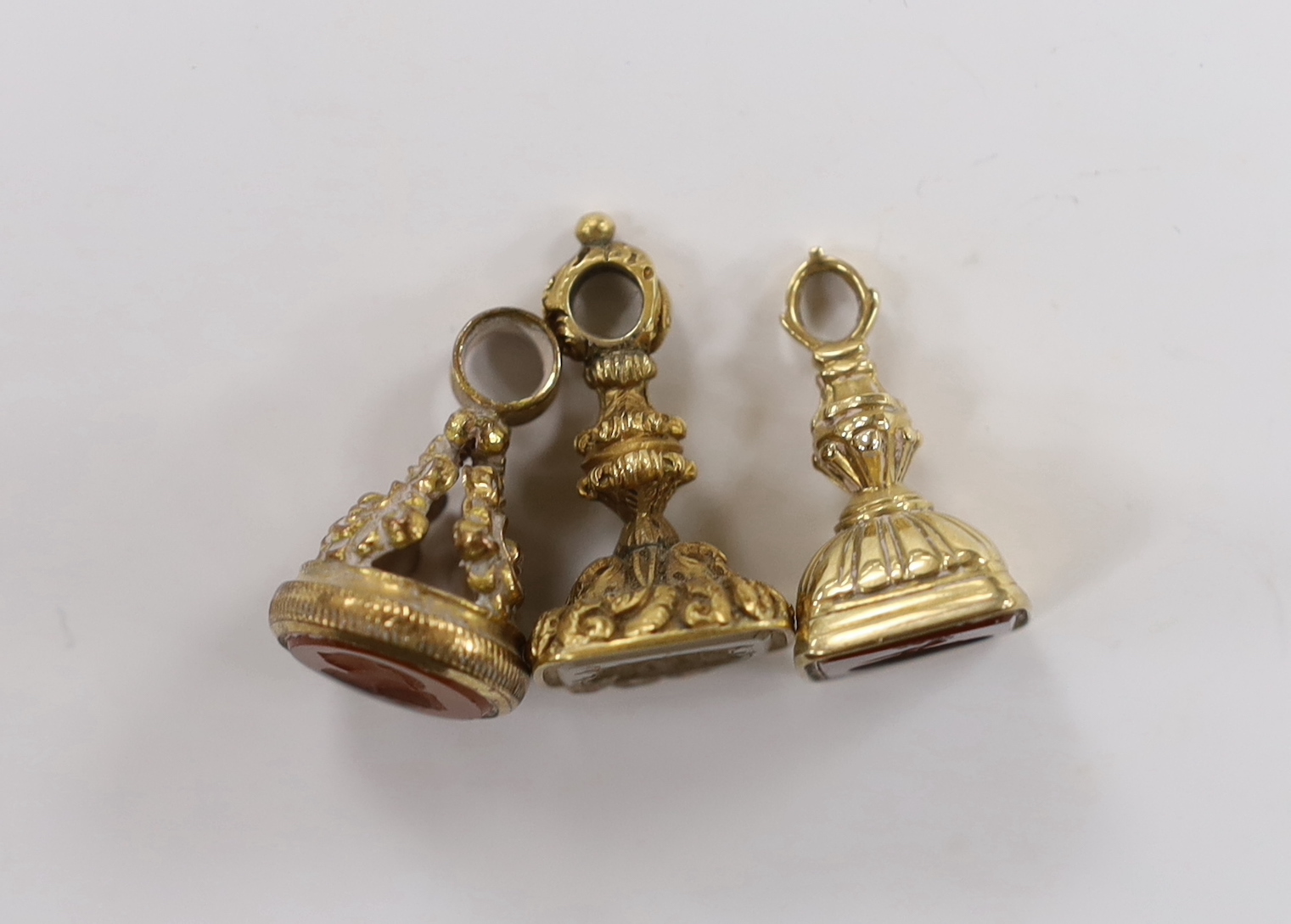 Three assorted 19th century carnelian set fob seals, including one gold plated and two yellow metal overlaid, largest 30mm.